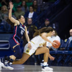 
              Connecticut's Nika Mühl (10) and Notre Dame's Maddy Westbeld (21) fight for possession during the first half of an NCAA college basketball game on Sunday, Dec. 4, 2022, in South Bend, Ind. (AP Photo/Michael Caterina)
            