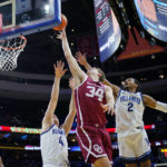 
              Oklahoma's Jacob Groves (34) goes up for a shot between Villanova's Chris Arcidiacono (4) and Mark Armstrong (2) during the second half of an NCAA college basketball game, Saturday, Dec. 3, 2022, in Philadelphia. (AP Photo/Matt Slocum)
            