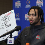 
              Ohio State quarterback C.J. Stroud (7) holds up his drawing of Ohio State mascot Brutus during media day for the Peach Bowl NCAA college football game against Georgia Thursday, Dec. 29, 2022, in Atlanta. (AP Photo/John Bazemore)
            