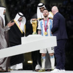 The Emir of Qatar Sheikh Tamim bin Hamad Al Thani puts on a cloak on Argentina's Lionel Messi after he won the World Cup final soccer match between Argentina and France at the Lusail Stadium in Lusail, Qatar, Sunday, Dec. 18, 2022. Argentina won 4-2 in a penalty shootout after the match ended tied 3-3. (AP Photo/Martin Meissner)