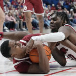 
              Oklahoma guard Grant Sherfield, left, and Arkansas forward Kamani Johnson, right, fight for control of the ball in the second half of an NCAA college basketball game Saturday, Dec. 10, 2022, in Tulsa, Okla. (AP Photo/Sue Ogrocki)
            
