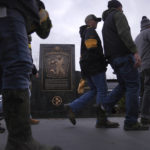 
              Pittsburgh Steelers fans walk past a marker commemorating the exact spot where the 1972 "Immaculate Reception," was made by Franco Harris at Three Rivers Stadium, which once stood on the North Side of Pittsburgh, on Sunday, Dec. 11, 2022, in Pittsburgh, Pa. Harris' scoop of a deflected pass and subsequent run for the winning touchdown in a 1972 playoff victory against Oakland has been voted the greatest play in NFL history and celebrates its 50th anniversary this year. (AP Photo/Jessie Wardarski)
            