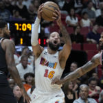 Miami Heat forward Caleb Martin (16) attempts to pass past Los Angeles Clippers forwards Paul George (13) and Marcus Morris Sr. (8) during the first half of an NBA basketball game, Thursday, Dec. 8, 2022, in Miami. (AP Photo/Wilfredo Lee)