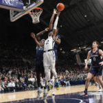 
              Butler guard Eric Hunter Jr., front center, shoots in front of Connecticut defenders Adama Sanogo, left, Tristen Newton, behind, and Alex Karaban (11) in the first half of an NCAA college basketball game in Indianapolis, Saturday, Dec. 17, 2022. (AP Photo/AJ Mast)
            