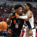 
              Miami guard Jordan Miller (11) tries to get past Louisville forward JJ Traynor (12) during the first half of an NCAA college basketball game in Louisville, Ky., Sunday, Dec. 4, 2022. (AP Photo/Timothy D. Easley)
            