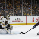 Colorado Avalanche's Nathan MacKinnon tries to deflect a shot past Boston Bruins goaltender Linus Ullmark during the first period of an NHL hockey game Saturday, Dec. 3, 2022, in Boston. (AP Photo/Winslow Townson)