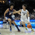 
              Xavier guard Colby Jones (3) dribbles against Connecticut's Andre Jackson Jr. (44) during the first half of an NCAA college basketball game, Saturday, Dec. 31, 2022, in Cincinnati. (AP Photo/Jeff Dean)
            