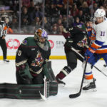 Arizona Coyotes goaltender Karel Vejmelka (70) makes a save in front of New York Islanders left wing Zach Parise (11) in the second period during an NHL hockey game, Friday, Dec. 16, 2022, in Tempe, Ariz. (AP Photo/Rick Scuteri)