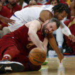 New York Knicks guard Jalen Brunson, top, and Cleveland Cavaliers forward Kevin Love fight for the ball during the second half of an NBA basketball game, Sunday, Dec. 4, 2022, in New York. The Knicks won 92-81. (AP Photo/John Munson)