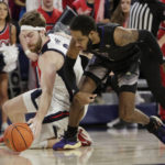 Gonzaga forward Drew Timme, left, and Washington guard PJ Fuller II go after the ball during the first half of an NCAA college basketball game, Friday, Dec. 9, 2022, in Spokane, Wash. (AP Photo/Young Kwak)