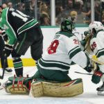 
              Dallas Stars left wing Jamie Benn (14) tries to get the puck past Minnesota Wild goaltender Marc-Andre Fleury (29) and Connor Dewar (26) during the first period of an NHL hockey game in Dallas, Sunday, Dec. 4, 2022. (AP Photo/LM Otero)
            
