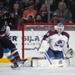 Colorado Avalanche goaltender Alexandar Georgiev, right, makes a save as Arizona Coyotes defenseman Shayne Gostisbehere, Avalanche center Andrew Cogliano (11) and Coyotes center Travis Boyd (72) collide during the second period of an NHL hockey game in Tempe, Ariz., Tuesday, Dec. 27, 2022. (AP Photo/Ross D. Franklin)