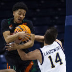 Miami's Nijel Pack, left, and Notre Dame's Nate Laszewski (14) fight for a loose ball during the first half of an NCAA college basketball game Friday, Dec. 30, 2022 in South Bend, Ind. (AP Photo/Michael Caterina)
