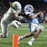North Carolina quarterback Drake Maye (10) is tackled by Oregon defensive lineman Casey Rogers (98) during the second half of the Holiday Bowl NCAA college football game Wednesday, Dec. 28, 2022, in San Diego. (AP Photo/Denis Poroy)