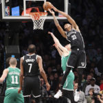 
              Brooklyn Nets forward Nic Claxton (33) scores a basket against Boston Celtics forward Sam Hauser as Boston Celtics guard Payton Pritchard (11) and Brooklyn Nets forward Kevin Durant (7) watch during the first half of an NBA basketball game, Sunday, Dec. 4, 2022, in New York. (AP Photo/Jessie Alcheh)
            