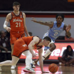
              Virginia Tech's Hunter Cattoor stubbles while guarded by North Carolina's Caleb Love in the first half of an NCAA college basketball game in Blacksburg Va., Sunday Dec. 4, 2022. (Matt Gentry/The Roanoke Times via AP)
            