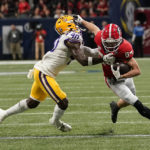 Georgia wide receiver Ladd McConkey (84) deflects the tackle against LSU linebacker Harold Perkins Jr. (40) first half of the Southeastern Conference championship NCAA college football game, Saturday, Dec. 3, 2022, in Atlanta. (AP Photo/Brynn Anderson)