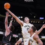 Purdue center Zach Edey (15) grabs a rebound over Davidson guard Foster Loyer (0) in the first half of an NCAA college basketball game in Indianapolis, Saturday, Dec. 17, 2022. (AP Photo/Michael Conroy)