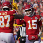 Kansas City Chiefs quarterback Patrick Mahomes (15) and tight end Travis Kelce (87) celebrate during the first half of an NFL football game against the Seattle Seahawks Saturday, Dec. 24, 2022, in Kansas City, Mo. (AP Photo/Ed Zurga)