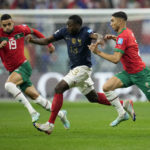 France's Youssouf Fofana, center, vies for the ball with Morocco's Youssef En-Nesyri and Achraf Hakimi, right, during the World Cup semifinal soccer match between France and Morocco at the Al Bayt Stadium in Al Khor, Qatar, Wednesday, Dec. 14, 2022. (AP Photo/Christophe Ena)