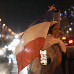 Supporters of France react on the Champs Elysees avenue at the end of the World Cup semifinal soccer match between France and Morocco, in Paris, Wednesday, Dec. 14, 2022. (AP Photo/Thibault Camus)