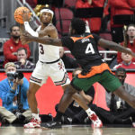 Louisville guard El Ellis (3) looks for help from the pressure from Miami guard Bensley Joseph (4) during the first half of an NCAA college basketball game in Louisville, Ky., Sunday, Dec. 4, 2022. (AP Photo/Timothy D. Easley)