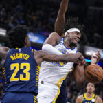 
              Indiana Pacers forward Aaron Nesmith (23) strips the ball from Golden State Warriors center Kevon Looney (5) during the first half of an NBA basketball game in Indianapolis, Wednesday, Dec. 14, 2022. (AP Photo/Michael Conroy)
            