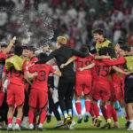 Players of South Korea celebrate after their team's 2-1 victory over Portugal at the end of the World Cup group H soccer match between South Korea and Portugal, at the Education City Stadium in Al Rayyan, Qatar, Friday, Dec. 2, 2022. (AP Photo/Ariel Schalit)