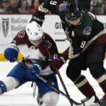 Colorado Avalanche left wing Charles Hudon (54) and Arizona Coyotes right wing Clayton Keller (9) vie for the puck during the third period of an NHL hockey game in Tempe, Ariz., Tuesday, Dec. 27, 2022. The Coyotes won 6-3. (AP Photo/Ross D. Franklin)