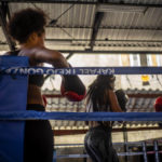 
              Boxer Giselle Bello Garcia, left, watches as fellow female boxers train in Havana, Cuba, Monday, Dec. 5, 2022. Cuban officials announced on Monday that women boxers would be able to compete for the first time ever. (AP Photo/Ramon Espinosa)
            
