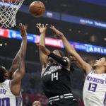 Los Angeles Clippers guard Terance Mann, center, shoots as Sacramento Kings forward Harrison Barnes, left, and forward Keegan Murray defend during the first half of an NBA basketball game Saturday, Dec. 3, 2022, in Los Angeles. (AP Photo/Mark J. Terrill)