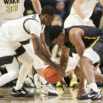 
              Wake Forest guard Daivien Williamson (4) and Appalachian State forward Donovan Gregory (11) vie for a loose ball in the first half of an NCAA college basketball game on Wednesday, Dec. 14, 2022, at Joel Coliseum in Winston-Salem, N.C. (Allison Lee Isley/The Winston-Salem Journal via AP)
            