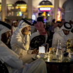 
              Men sit at the terrace of a restaurant in Doha, Qatar, Wednesday, Dec. 7, 2022. (AP Photo/Manu Fernandez)
            