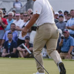 FILE - Tom Kim, of South Korea, watches his team-winning putt go in on the 18th green during their four ball match at the Presidents Cup golf tournament at the Quail Hollow Club, Saturday, Sept. 24, 2022, in Charlotte, N.C.  It was his 2-iron into the green that set up the win. (AP Photo/Chris Carlson, File)