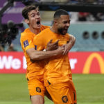 Memphis Depay of the Netherlands, right, celebrates with a teammate after scoring the opening goal of his team during the World Cup round of 16 soccer match between the Netherlands and the United States, at the Khalifa International Stadium in Doha, Qatar, Saturday, Dec. 3, 2022. (AP Photo/Martin Meissner)
