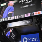 A graphic welcoming WNBA player Brittney Griner back to the United States, following her release in a prisoner swap with Russia, is shown on the scoreboard during an NBA basketball game between the Houston Rockets and the San Antonio Spurs, Thursday, Dec. 8, 2022, in San Antonio. (AP Photo/Darren Abate)