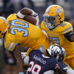 Southern University running back Braelen Morgan (30) is tackled by Jackson State defensive back Delano Salgado (29) during the first half of the Southwestern Athletic Conference championship NCAA college football game Saturday, Dec. 3, 2022, in Jackson, Miss. (AP Photo/Rogelio V. Solis)