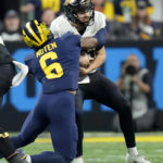 Purdue quarterback Aidan O'Connell is stopped by Michigan defensive back R.J. Moten (6) during the first half of the Big Ten championship NCAA college football game, Saturday, Dec. 3, 2022, in Indianapolis. (AP Photo/AJ Mast)
