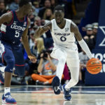 Xavier guard Souley Boum (0) dribbles against Connecticut's Hassan Diarra (5) during the first half of an NCAA college basketball game, Saturday, Dec. 31, 2022, in Cincinnati. (AP Photo/Jeff Dean)