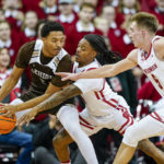 
              Wisconsin's Kamari McGee, center, Tyler Wahl reach in on Lehigh's Evan Taylor (5) during the second half of an NCAA college basketball game Thursday, Dec. 15, 2022, in Madison, Wis. Wisconsin won 78-56. (AP Photo/Andy Manis)
            