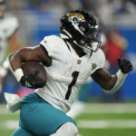 
              Jacksonville Jaguars running back Travis Etienne Jr. rushes during the first half of an NFL football game against the Detroit Lions, Sunday, Dec. 4, 2022, in Detroit. (AP Photo/Paul Sancya)
            