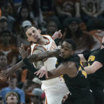 
              Texas forward Christian Bishop, left, and Arkansas-Pine Bluff guard Shaun Doss Jr., center, battle for a loose ball during the first half of an NCAA college basketball game in Austin, Texas, Saturday, Dec. 10, 2022. (AP Photo/Eric Gay)
            