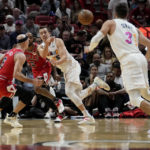 
              Miami Heat forward Duncan Robinson, center, passes the ball to guard Max Strus (31) as Chicago Bulls guard Alex Caruso (6) defends during the first half of an NBA basketball game, Tuesday, Dec. 20, 2022, in Miami. (AP Photo/Lynne Sladky)
            