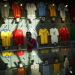 
              A man walks past international football teams jerseys displayed in a temporary exhibition room in Katara area in Doha, Qatar, Wednesday, Dec. 7, 2022. (AP Photo/Francisco Seco)
            