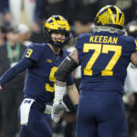 Michigan quarterback J.J. McCarthy (9) is congratulated by Trevor Keegan (77) after throwing a touchdown pass during the first half of the Big Ten championship NCAA college football game against Purdue, Saturday, Dec. 3, 2022, in Indianapolis. (AP Photo/Darron Cummings)