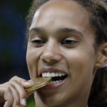FILE - United States' Brittney Griner bites her gold medal after beating Spain at the 2016 Summer Olympics in Rio de Janeiro, Brazil, Saturday, Aug. 20, 2016. Griner had for years been known to fans of women's basketball, college player of the year, a two-time Olympic gold medalist and WNBA all-star who dominated her sport. But her arrest on drug-related charges at a Moscow airport in February elevated her profile in ways neither she nor her supporters would have ever hoped for, making her by far the most high-profile American to be jailed abroad. (AP Photo/Eric Gay, File)