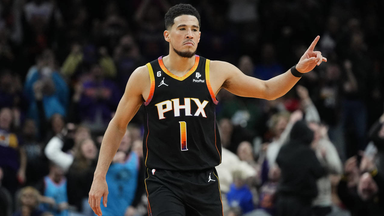 Phoenix Suns guard Devin Booker reacts to a basket during the second half of an NBA basketball game...