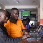 
              Shop manager David Mugisa, center, helps a customer at the Fortebet sports betting shop in the Ntinda area of the capital Kampala, Uganda, Tuesday, Dec. 6, 2022. In Uganda, an East African country where annual income per capita was $840 in 2020, many see sports betting as a path to survival and perhaps even prosperity. (AP Photo/Hajarah Nalwadda)
            