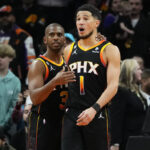 Phoenix Suns guard Chris Paul (3) embraces guard Devin Booker after Booker made a basket during the second half of an NBA basketball game against the New Orleans Pelicans, Saturday, Dec. 17, 2022, in Phoenix. The Suns defeated the Pelicans 118-114. (AP Photo/Matt York)