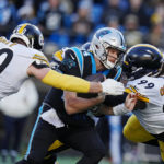 Carolina Panthers quarterback Sam Darnold is sacked by Pittsburgh Steelers linebacker T.J. Watt, left, and defensive tackle Larry Ogunjobi during the second half of an NFL football game between the Carolina Panthers and the Pittsburgh Steelers on Sunday, Dec. 18, 2022, in Charlotte, N.C. (AP Photo/Rusty Jones)
